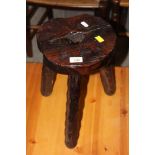 A stained and carved pine milking stool,
