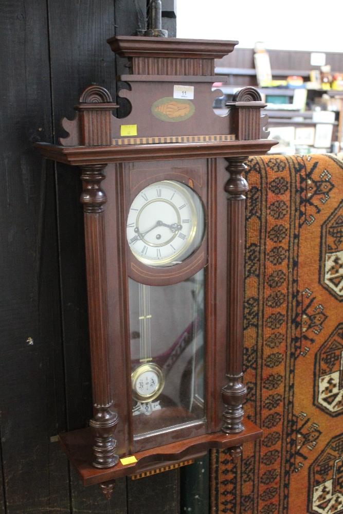 An inlaid mahogany Vienna style wall clock with three train movement