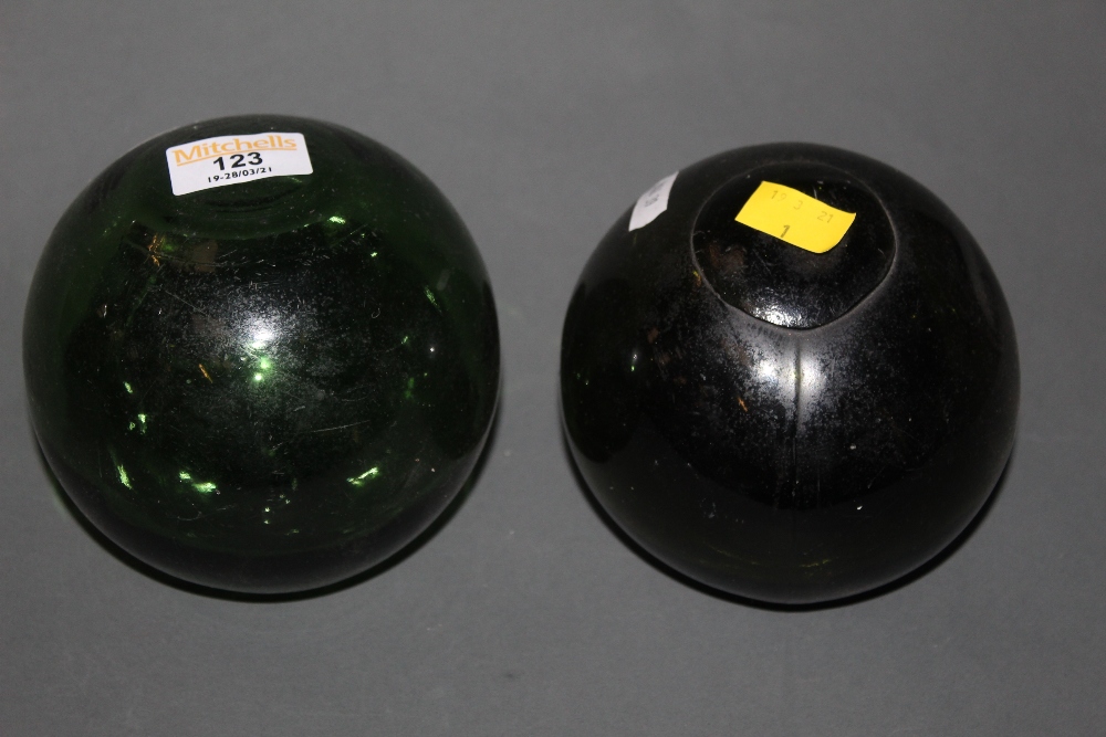 Two green glass fishing floats, a wooden