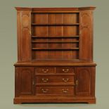 A late Victorian oak dresser with rack above,