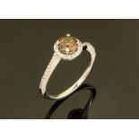 An 18 ct white gold ring, set with a natural intense fancy brown diamond to twist diamond halo,
