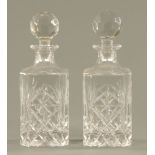 A pair of cut glass spirit decanters, 20th century, each with faceted knop and square bodies.