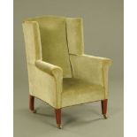 An Edwardian mahogany wing chair, upholstered in green velvet type material with braiding,