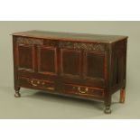 An early 18th century four panelled oak mule chest,