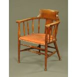 An Edwardian desk chair, with scroll back with outswept arms with spindle supports,