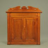 An Edwardian walnut cabinet, with rear upstand and two doors and raised on a plinth base.
