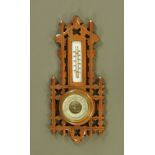 A late Victorian/ Edwardian walnut aesthetic movement aneroid barometer with thermometer.