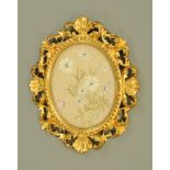 An oval needlework panel, initialled and housed within a Florentine giltwood frame.