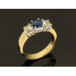 An 18 ct gold sapphire and diamond three stone ring, sapphire +/- 0.90 carats, diamonds +/- 0.