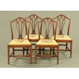 A set of four George III mahogany dining chairs, with arched top rails,
