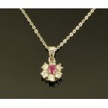 An 18 ct white gold diamond and ruby pendant, with 18 ct white gold chain, pendant diameter 8 mm.