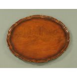 A George III style mahogany tray with piecrust edge, diameter 48 cm.