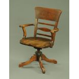 A 19th century Scottish birch swivel office armchair, with bowed top rail,