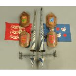 A jousting kit, comprising two lances, four shields, various banners and stands.