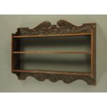 A Victorian oak bookcase, with carved swans neck pediment above three shelves.