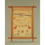 A Victorian sampler 1888, alphabet, vases and floral designs. 65 cm x 44 cm in oak frame.