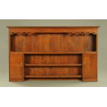 A George III oak Delft rack, with moulded cornice open shelves and cupboards.