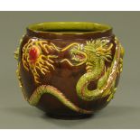 A large Bretby jardiniere, moulded with chasing dragons and decorated in bright green, pink,