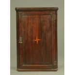 A George III oak hanging corner cupboard,