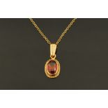 A 9 ct gold garnet set pendant and chain.