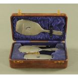 A cased silver dressing table set, comprising mirror, comb and two brushes,