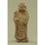 A Japanese terracotta figure of Daruma, in typical standing pose. Height 38 cm (see illustration).