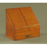 A Victorian oak slope front writing and stationery box with fitted interior. Width closed 38 cm.