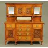A late Victorian Arts and Crafts oak sideboard, in two sections with cupboards,