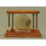 An Edwardian oak table gong, the circular gong flanked by double pillars. Width 47 cm.