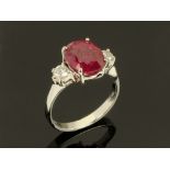 An 18 ct gold oval ruby and diamond three stone ring, ruby 4.34 carats, diamonds +/- 0.31 carats.