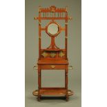 An Edwardian oak hall stand, with circular mirror, tiles, drawer and low shelf.