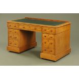 An early 20th century oak pedestal desk, with green tooled leather writing surface,