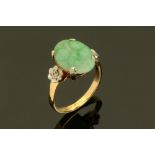 An 18 ct gold jade ring, with carved stone. Size L/M.