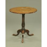 A George III oak circular topped tripod occasional table raised on three downswept legs terminating