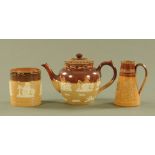 Three pieces of Doulton Lambeth salt glazed wares, comprising teapot, biscuit barrel and jug.