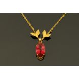 A 9 ct gold leaf shaped pendant and chain, with ruby coloured stone.