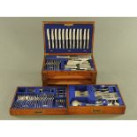 An oak canteen containing a quantity of silver plated cutlery, comprising 12 table knives and forks,