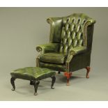 A Queen Anne style green leather upholstered wing chair with stool,