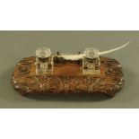 A Victorian carved oak desk stand, with two glass inkwells and dip pen. Length 38 cm.