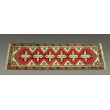 A Turkish runner, the centre rectangular panel with repeating designs and with multiple line border,