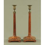 A pair of Edwardian mahogany candlesticks, with fluted columns and brass sconces,
