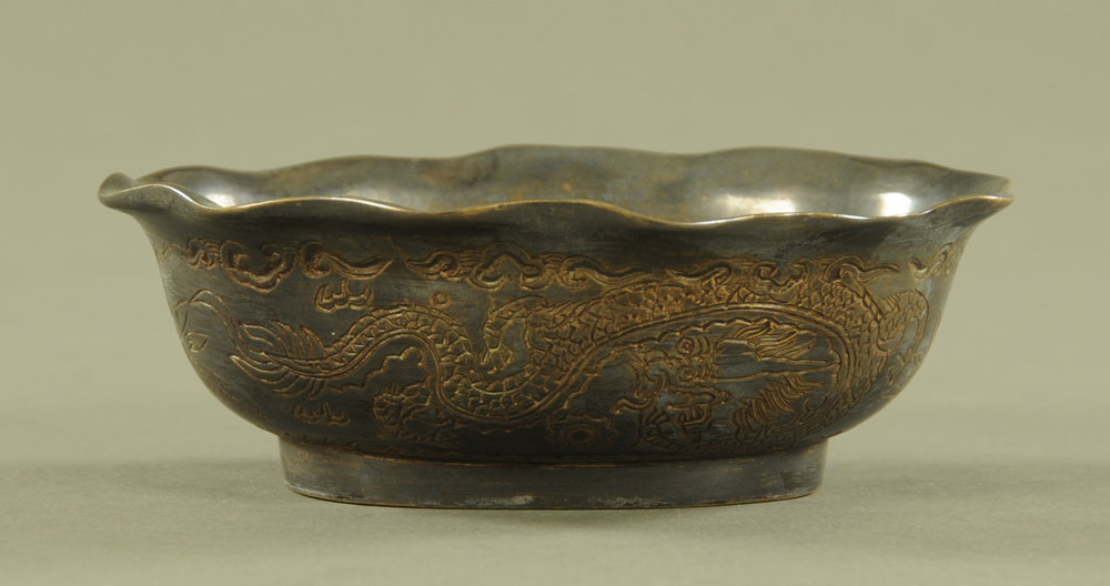 A Chinese bronze dish, decorated with dragons and with character mark to base. Length 15 cm.