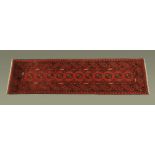 A Turkish woollen runner, principal colours red and black. 67 cm x 236 cm.