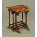 A nest of three mahogany occasional tables, with ring turned supports and sledge feet.