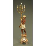 A composition Blackamoor lamp standard, five branch, painted and raised on a rococo style base.
