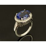 An 18 ct white gold ring, set with an oval cut tanzanite and small diamonds, weight +/- 8.72 ct.