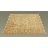 A Turkish woollen rug, principal colours beige, pink and yellow,