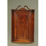 A George III mahogany hanging corner cupboard,