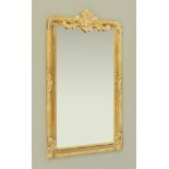 A composition and gilt painted wooden framed rectangular bevelled glass mirror,