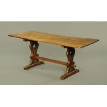 An oak refectory table, with pierced end supports and raised centre stretcher and with sledge feet.